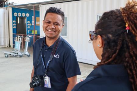 A man smiling next to another person