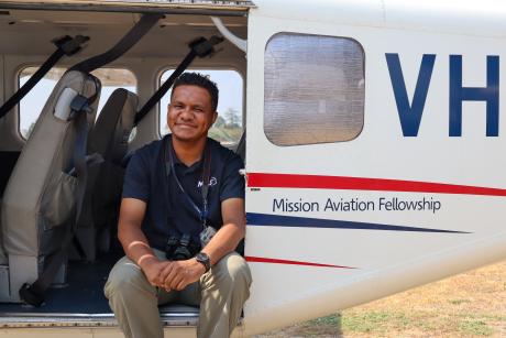 A man sits in a plane smiling