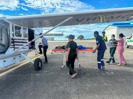 A stretcher patient is loaded onto small plane